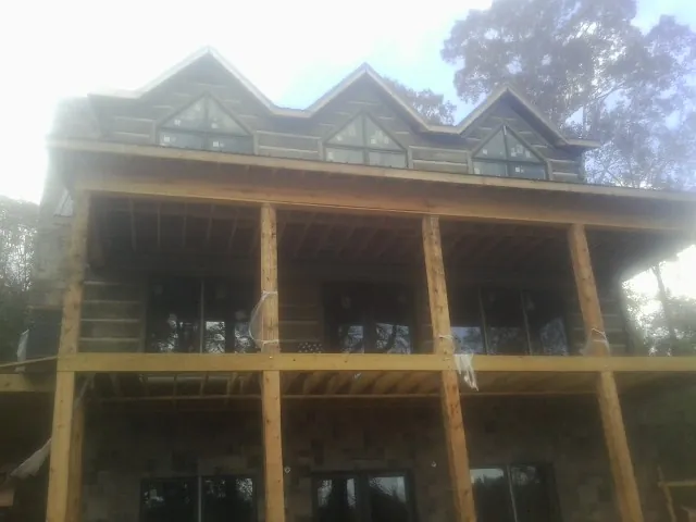 Dormers and porch framing on a large log home under construction — Roof Coating work by our crew in Sheboygan