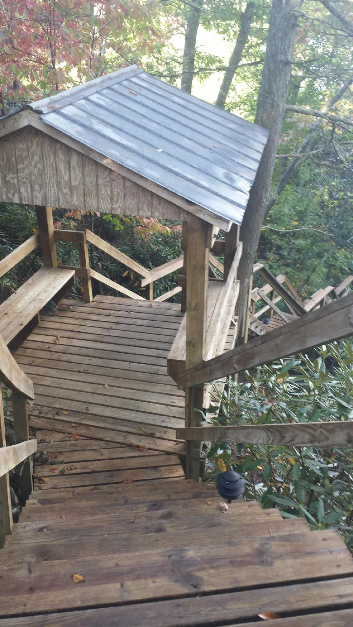 Metal roofed shelter over wooden steps on a wooded walkway — Skylight Repair & Installation work by our crew in Sheboygan