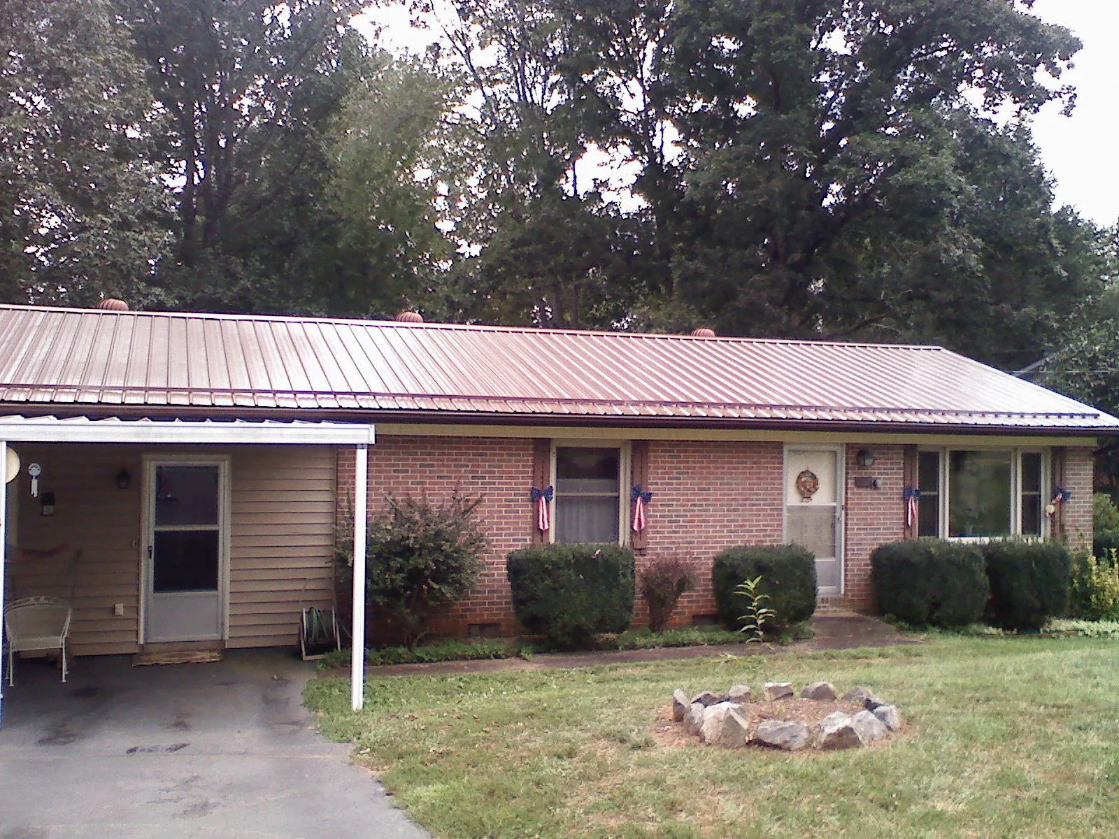 Bronze metal roof and carport on a brick ranch home — Roof Repair work by our crew in Sheboygan