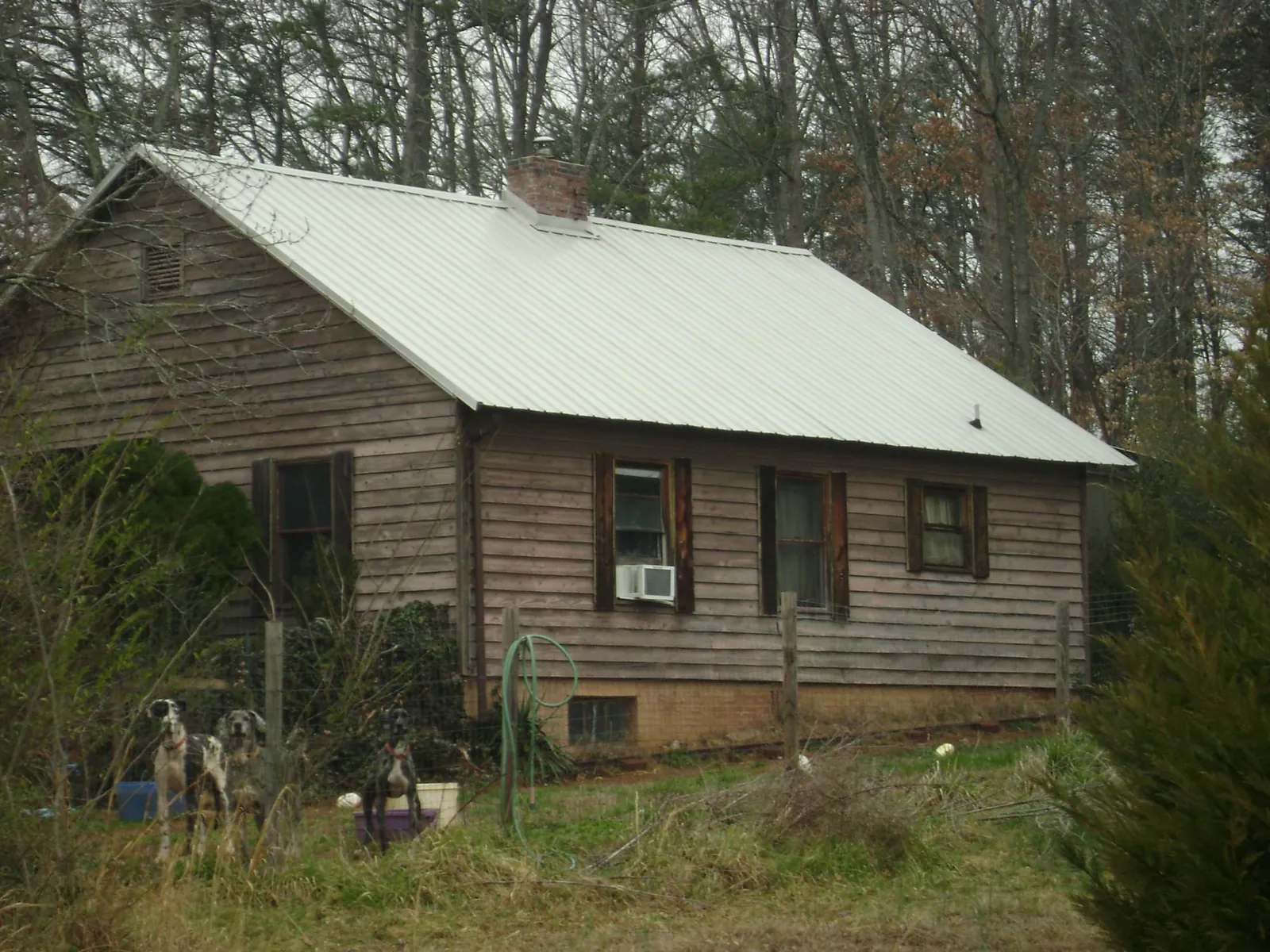 White metal roof on an old wood sided farmhouse, from a Asphalt Shingle Roof Repair job in Sheboygan